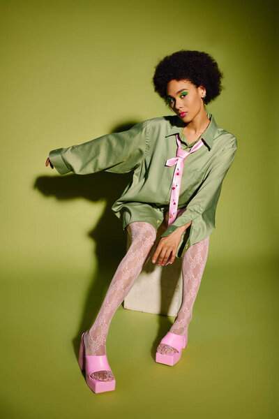 Молодая эмоциональная женщина излучает уверенность, демонстрируя свой уникальный стиль и поразительную позу.