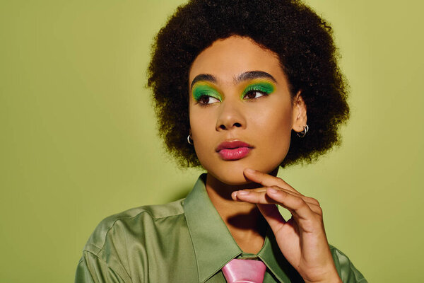 A young woman exhibits her vibrant makeup while conveying deep emotions against a stunning backdrop.