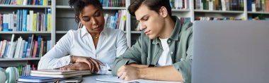 A young student receives focused support and guidance from his teacher in a library. clipart