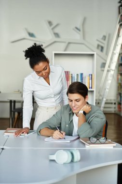 Profesyonel bir eğitimci modern bir sınıfta öğrencisine odaklanması için yardım eder..