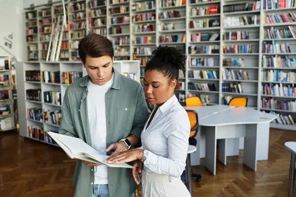 stock image A passionate educator supports her student in exploration within a lively library atmosphere.