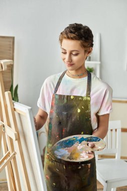 Parlak ve ilham verici bir mekanda, genç bir kadın sanat tutkusunu ifade eden bir resim yapar..