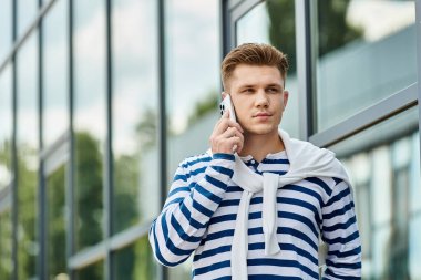 Protez bacaklı yakışıklı genç bir adam dışarıda bir telefon görüşmesi yapıyor..