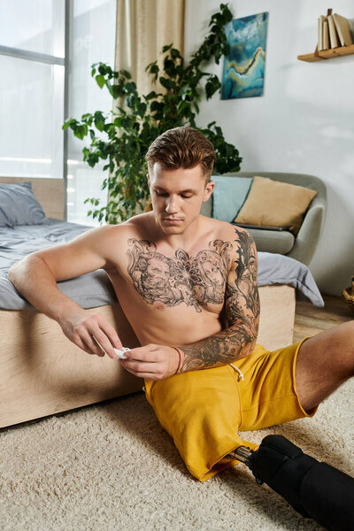 A young man sits comfortably on the floor, engaging with a small object, contemplating his journey.