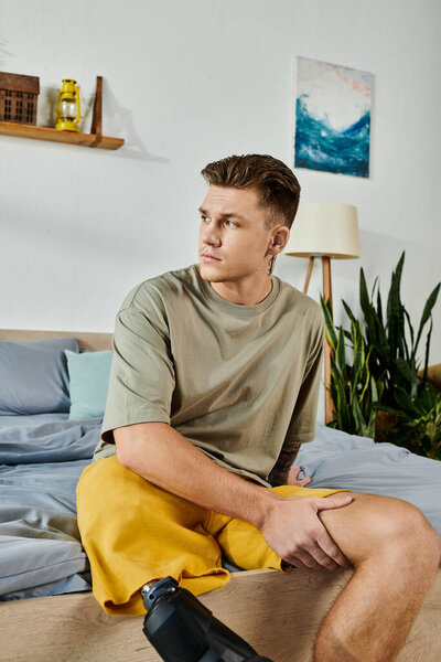 Молодой человек сидит на кровати, демонстрируя силу и уверенность протезом ноги..