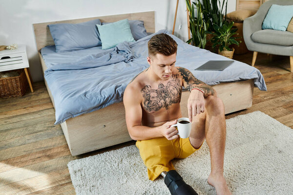 Молодой человек сидит удобно на полу, наслаждаясь кофе, размышляя в спокойной спальне.