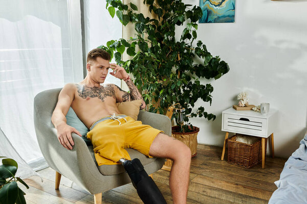 Красивый молодой человек, с вдумчивым выражением лица, расслабляется в стильном кресле дома.