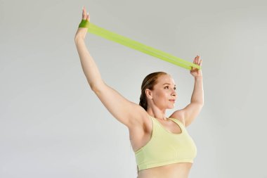 Kendini spora adamış bir kadın direniş bantlarıyla egzersiz yapıyor, güç ve forma odaklanıyor..