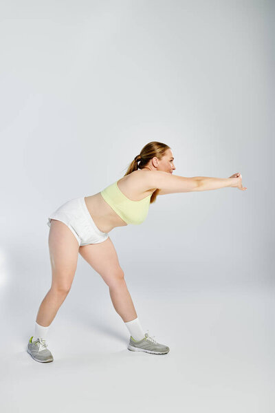 Самоотверженная женщина растягивает и раздвигает границы своих возможностей на тренировке.