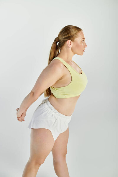 Специальная спортсменка в кукурузном топе занимается упражнениями на растяжку, чтобы согреться и повысить гибкость.