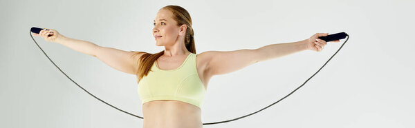 В яркой студии активная женщина практикует прыжки, демонстрируя свою преданность фитнесу и здоровью.