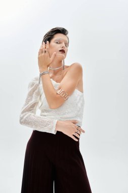 Güzel bir kadın zarif bir kış elbisesi içinde poz verir, tarzını ve zarafetini ön plana çıkarır..