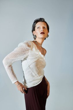 Güzel bir kadın zarif bir kış elbisesi içinde poz verir, kendine güven ve tarz saçar..