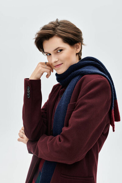 A stylish woman showcases an inviting winter look while offering a playful smile.