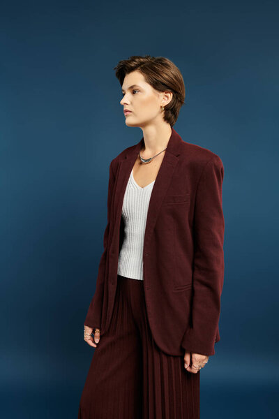 Потрясающая женщина демонстрирует уютную зимнюю одежду, излучающую элегантность на ярком фоне.