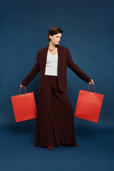 stock image A graceful woman dressed in cozy winter fashion proudly displays vibrant shopping bags.