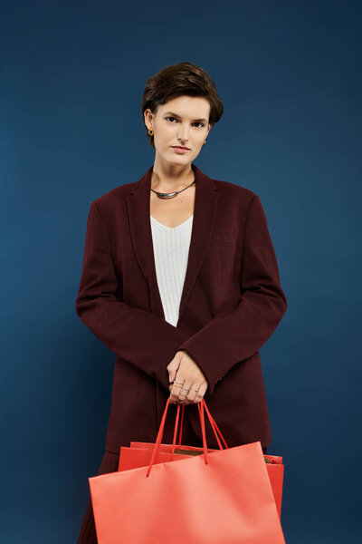 A poised woman in stylish winter attire confidently carries vibrant shopping bags.