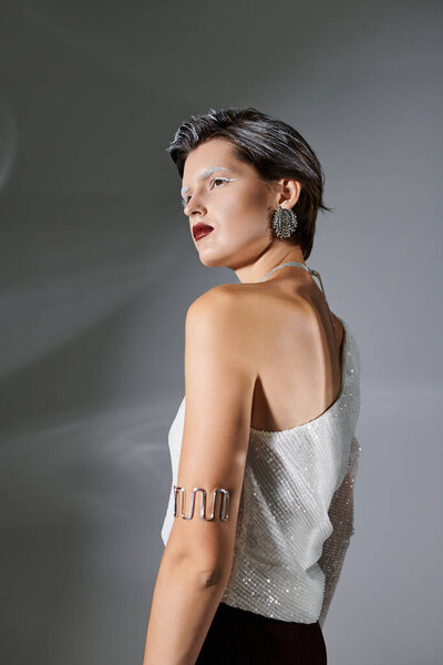 Красивая женщина демонстрирует уютный зимний наряд, излучающий оптимизм и уверенность в себе в помещении.