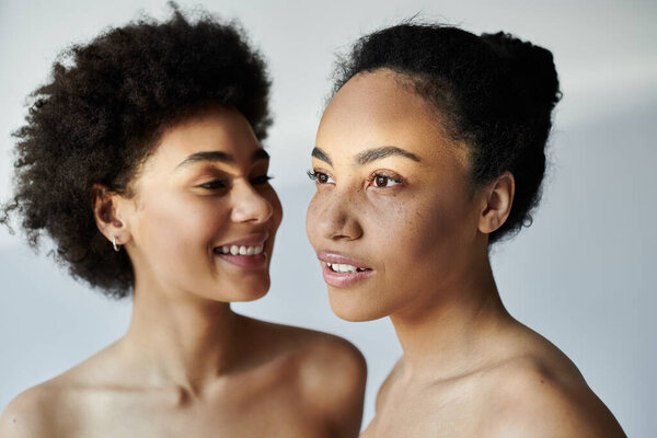 Two women share a moment of joy and friendship, showcasing their unique features and expressions.