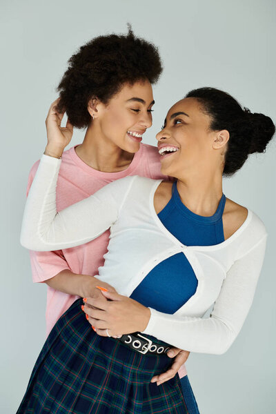 Two friends share a heartfelt moment, smiling and embracing each other in a colorful studio.