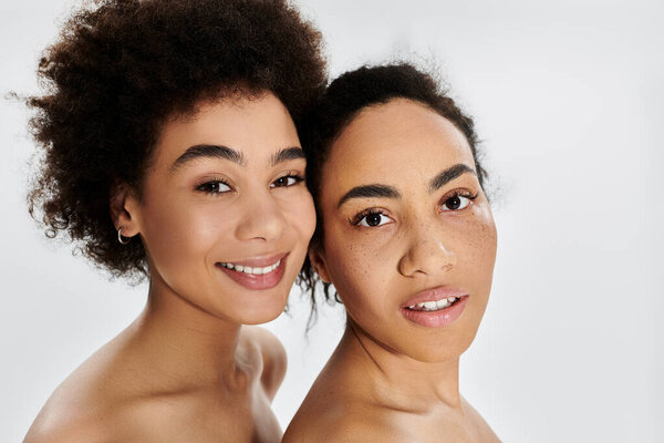 Two women showcase their natural beauty, beaming brightly with joy and confidence.