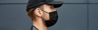 Siyah tıbbi maske takan bir kurye bir ofis binasına giriyor.