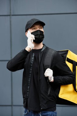 Maskeli bir teslimatçı, emrin ve verimliliğin sağlanması için ofise geliyor..