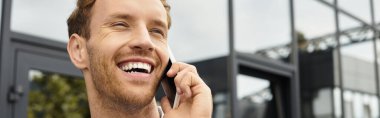 A redhead in a white shirt enthusiastically discusses his project while working in a stylish office. clipart