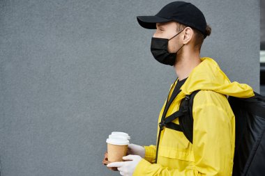 Eldiven takan ve maske takan bir teslimatçı gün içinde bir sipariş vermek için ofise gelir..