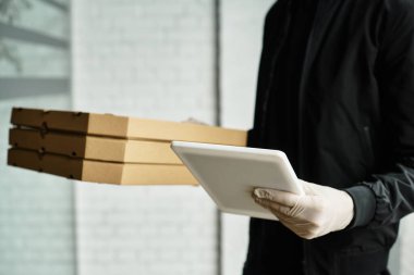 Eldiven takan bir teslimatçı ofis binasına paket getirir..