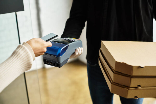 A delivery person arrives at an office building, handing over food orders to a customer with care.