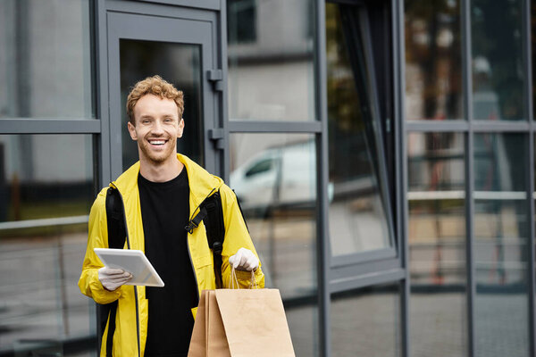 A delivery man brings an order into an office building, smiling cheerfully.