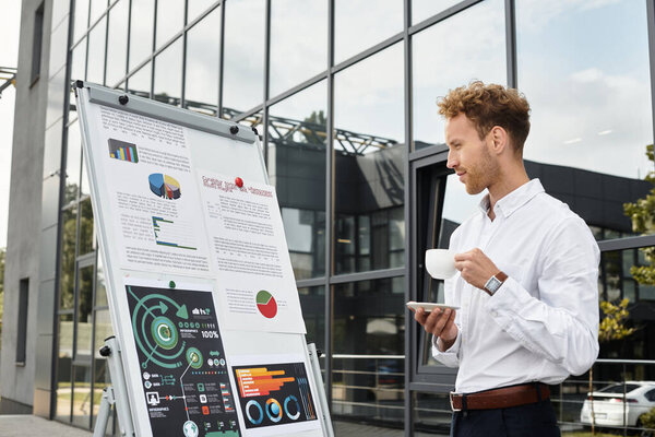 A focused businessman is analyzing a project progress while enjoying his coffee in a contemporary office.