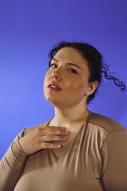 Güzel ve iri kadın köprücük kemiğine hafifçe dokunurken kendine güvenir..