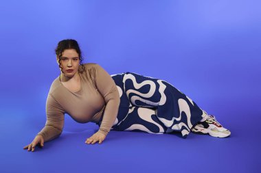 Büyüleyici artı boyut güzelliği, canlı arkaplanda poz verirken modern tarzı sergiliyor.