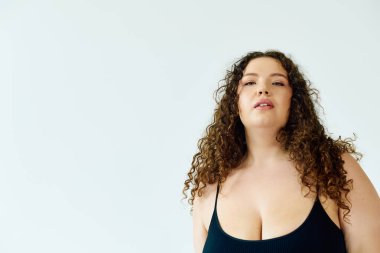 Modaya uygun ve cüsseli bir kadın kıvrımlarını kucaklıyor, kendine güveni ve cazibesi yayılıyor..