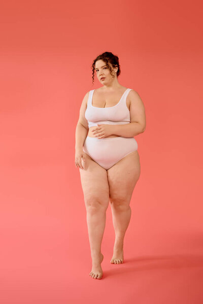 A confident plus size woman showcases her beauty in a pastel pink outfit, posing with grace.
