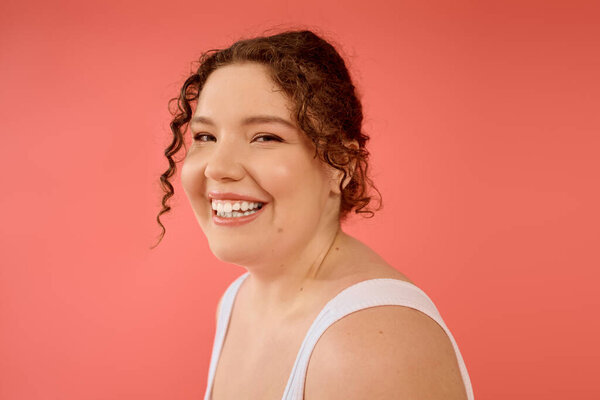 A cheerful plus size woman beams infectious joy, showcasing her confidence and beauty.