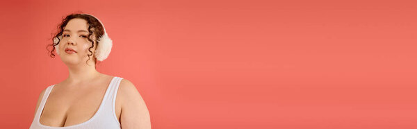 The plus size woman poses elegantly, showcasing her confidence in soft colors and accessories.