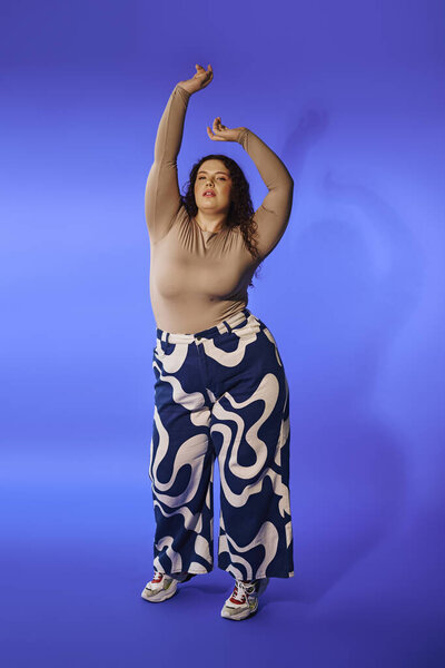 A confident plus size woman dances, radiating joy and empowerment in bright lights.