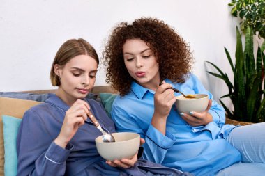 Evde rahat bir atmosferde lezzetli bir yemeğin tadını çıkaran iki eş..
