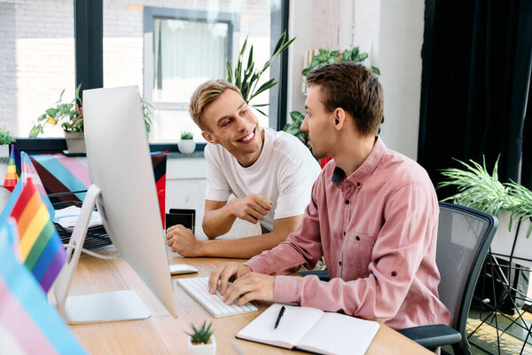 Двое мужчин разделяют радостный момент, сотрудничая за своим стильным столом, наполненным творчеством.