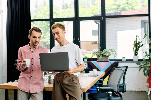 Two individuals engage in an inspiring conversation while working on a laptop.