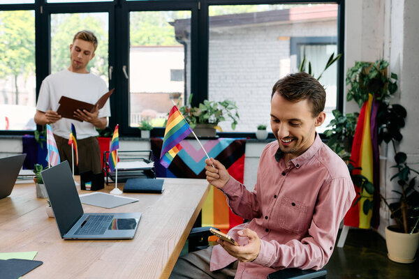 Красивая пара наслаждается своим временем в ярком офисе, окруженном флагами гордости и смехом.