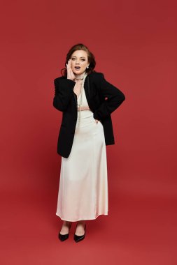 Sofistike bir kıyafet içinde, bir kadın neşeli bir poz verir, büyüleyici ve zarif..