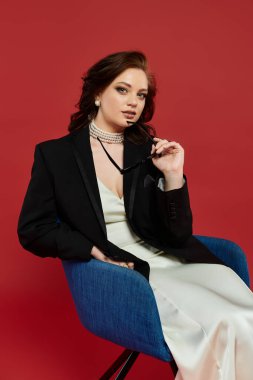 Zarif bir şekilde giyinmiş, genç ve güzel bir bayan zarif bir şekilde oturuyor, büyüleyici ve sofistike bir şekilde..