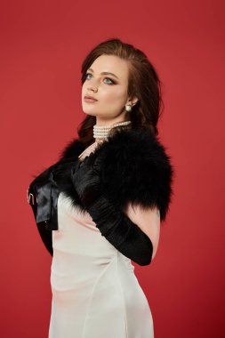 Genç ve güzel bir kadın zarafetini, sofistike bir giysi ve dengeli bir ifadeyle sergiliyor..