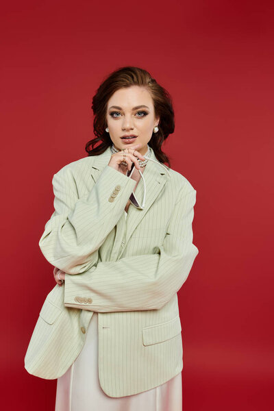 Красивая молодая женщина в элегантном наряде излучает уверенность в поразительной обстановке.