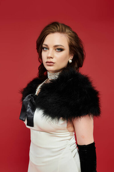 Потрясающая женщина демонстрирует свою элегантность со сложным костюмом и завораживающим выражением.