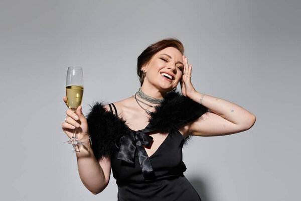 A young, beautiful woman enjoys a moment of joy while holding a glass of champagne gracefully.
